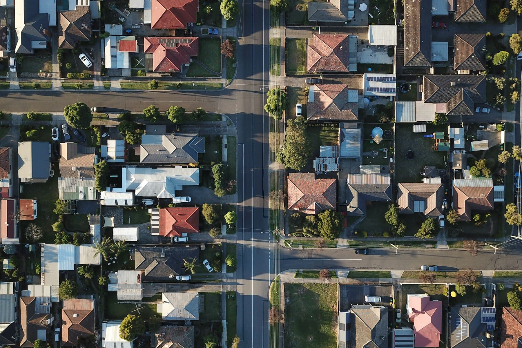 Aerial view over a suburban street, the property and the surrounding area from above.