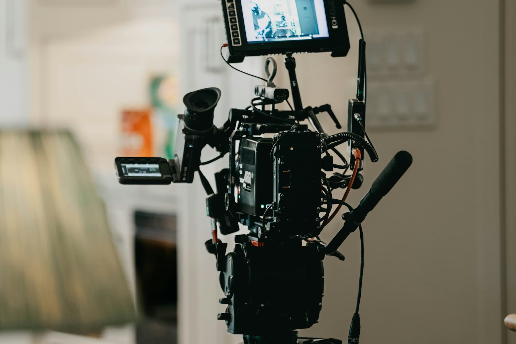 Cinema camera on a tripod filming inside a home for a property video.